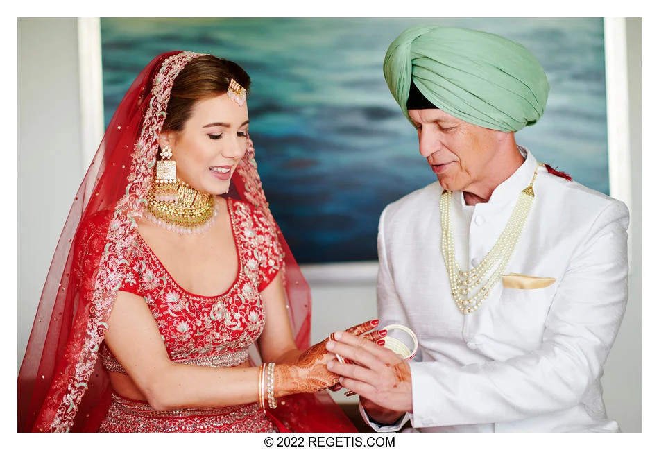 Alexandra having her bridal bangles placed on her wrists during wedding preparations.