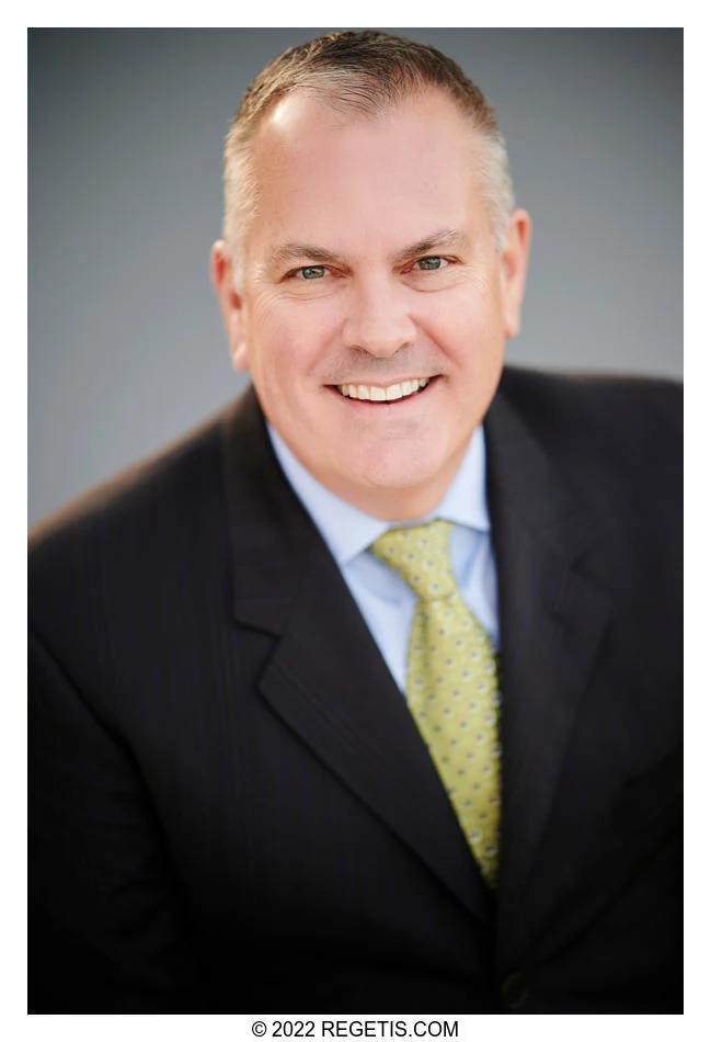 A real-estate professional in a dark suit and green tie, photographed in Warrenton by The Regeti’s