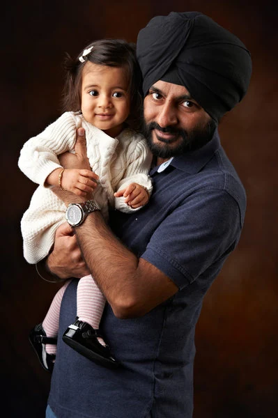 A father holding his daughter in a portrait by The Regeti’s