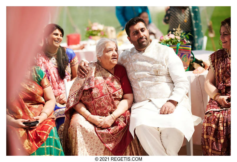 Nina’s cousin sits beside a grandparent with an arm around her shoulders during Nina and Manoj’s wedding celebration