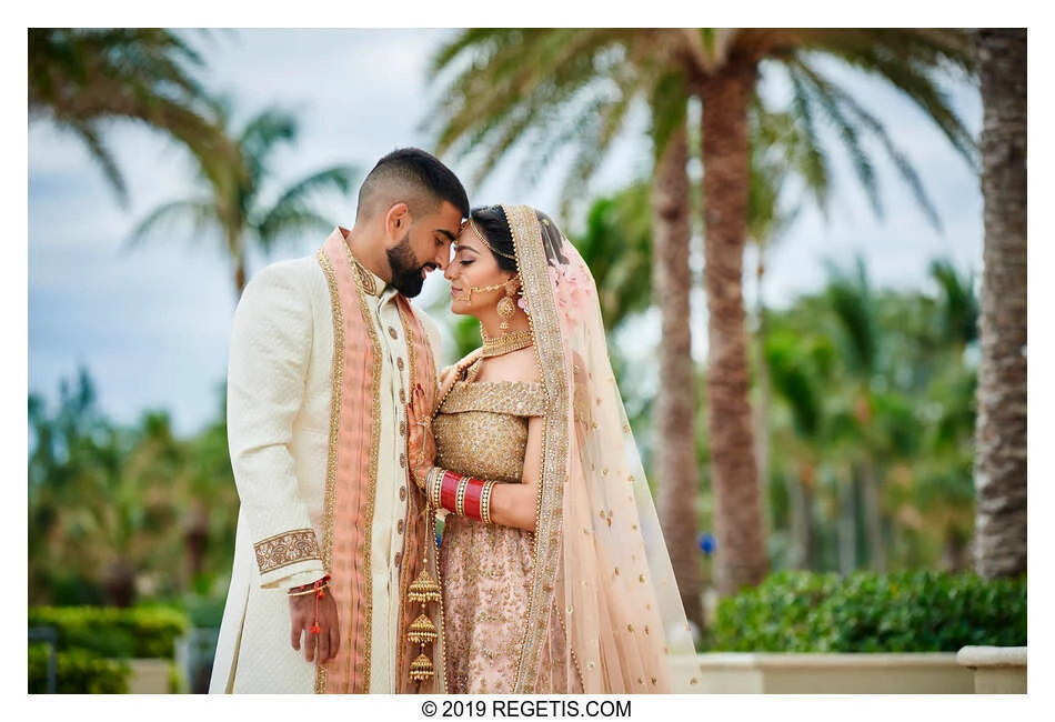 Lali and Amit touching foreheads beneath palm trees at their Fort Lauderdale wedding