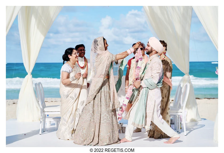 Namrata and Ashvin exchanging garlands beside the sea during their destination wedding in Punta Cana, Dominican Republic.