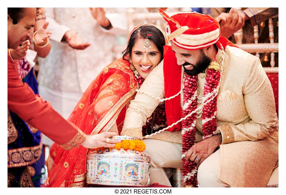 Nina playfully sticks out her tongue as she and Manoj reach into the decorated pot during their wedding ring game