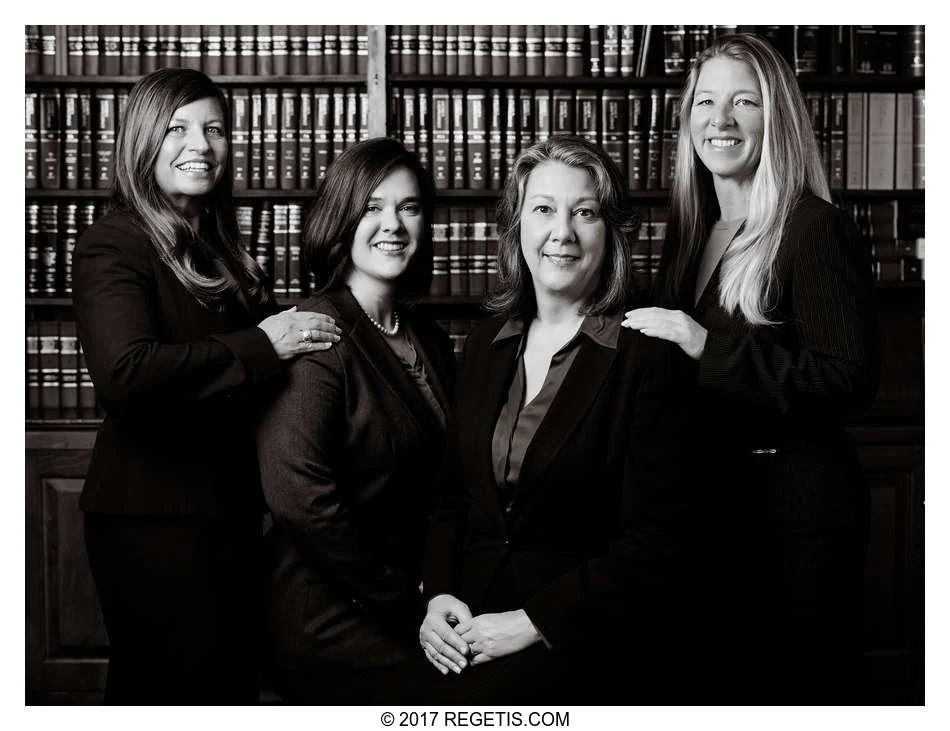 Four Walker Jones attorneys together in front of law-library bookshelves, photographed in black and white by The Regeti’s
