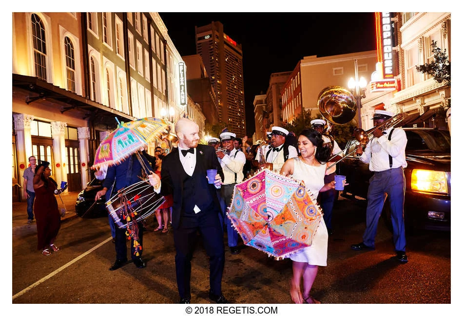 Rachna and Peter dancing with umbrellas and a brass band in a New Orleans street at night