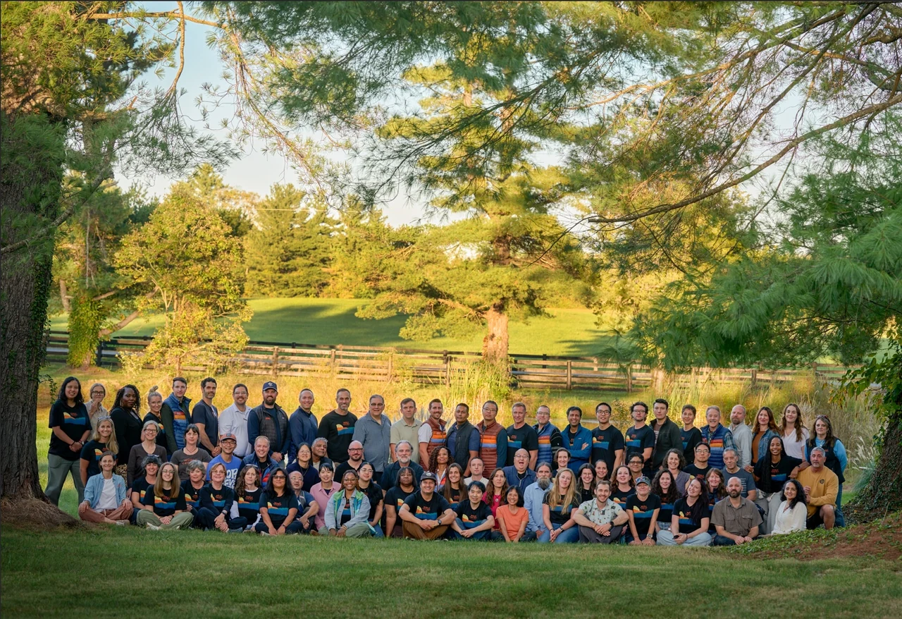 A large team gathered for an outdoor group portrait by The Regeti’s