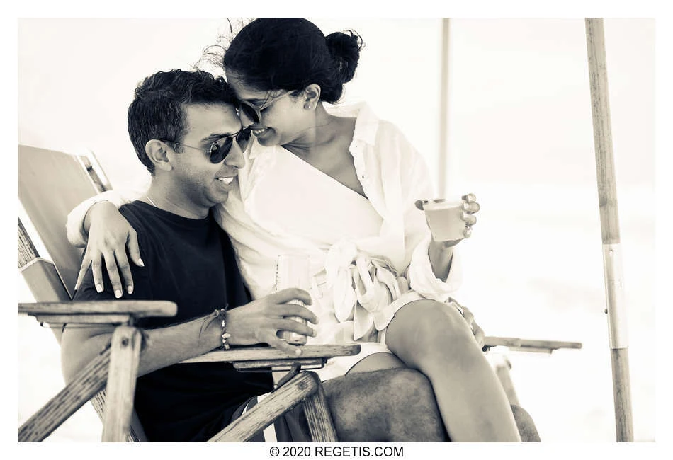 Shruthi and Arjun in sunglasses, leaning close together in a beach chair during their pre-wedding celebration